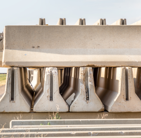Close-up view of a concrete bridge, highlighting its texture and structural details against a blurred background.