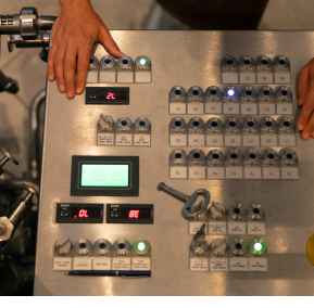 A person operates a machine, focused on their task in a workshop environment.