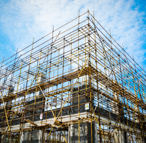 Scaffolding surrounds a building that is currently under construction, indicating ongoing renovation or development work.